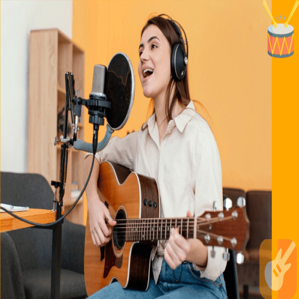 Female musician recording song and playing acoustic guitar at soundproofed home band room